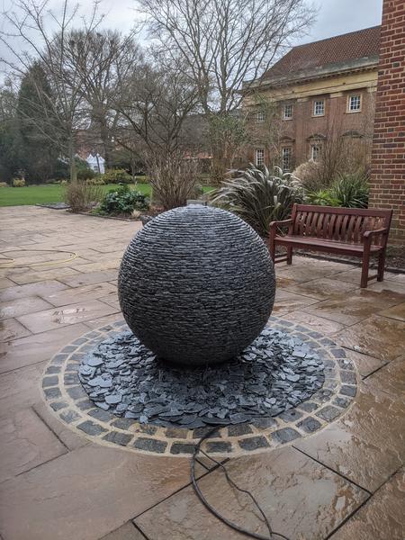 large grey slate water feature raised above slate chips